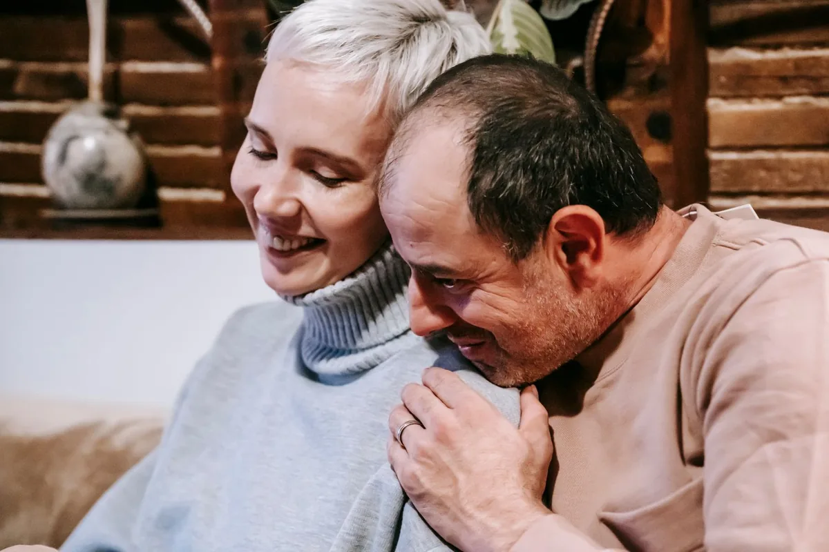 A relaxed middle-aged couple smiling together at home