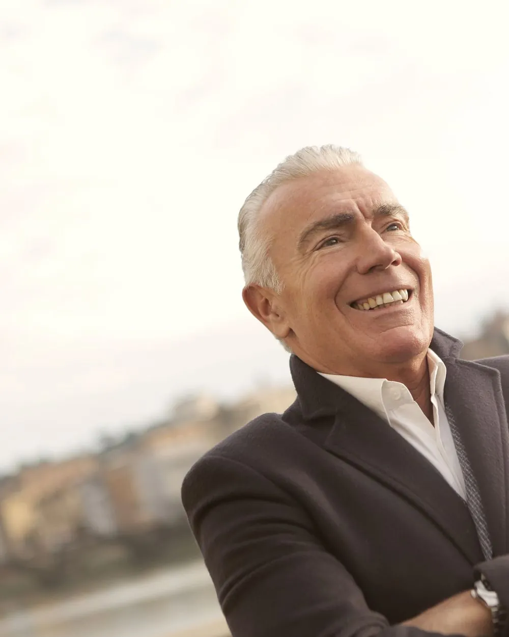 A confident older man smiling outdoors